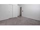 This is a simple carpeted room with closet, door, and neutral wall color at 43938 W Colby Dr, Maricopa, AZ 85138