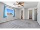This carpeted bedroom is spacious and bright with a ceiling fan and natural light at 43938 W Colby Dr, Maricopa, AZ 85138