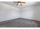 A simple bedroom features a ceiling fan and neutral carpeting at 43938 W Colby Dr, Maricopa, AZ 85138