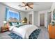 This is a bright staged bedroom with ceiling fan, a rug, and lots of natural light at 43938 W Colby Dr, Maricopa, AZ 85138