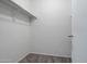A simple walk-in closet has carpeting, one shelf and a hanging bar at 43938 W Colby Dr, Maricopa, AZ 85138