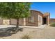 A well-kept home with desert landscaping and a mature shade tree in the front yard at 43938 W Colby Dr, Maricopa, AZ 85138