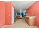 Spacious kitchen with stainless appliances, tile floors, and a cheerful orange accent wall at 43938 W Colby Dr, Maricopa, AZ 85138