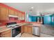 Kitchen with stainless dishwasher and oven featuring a view to the living room at 43938 W Colby Dr, Maricopa, AZ 85138