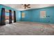 A living room featuring neutral carpet, a ceiling fan, and a sliding glass door to the outside at 43938 W Colby Dr, Maricopa, AZ 85138
