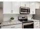 This updated kitchen features modern appliances, granite countertops and bright white cabinetry at 4502 E Carol Ave # 4, Mesa, AZ 85206