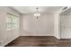 This spacious living room features hardwood floors, a large window and a simple chandelier at 4502 E Carol Ave # 4, Mesa, AZ 85206