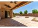 Covered back patio with ceiling fans, overlooks landscaped backyard with fire pit at 4724 S Anitole Way, Mesa, AZ 85212