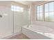 Bright bathroom featuring a soaking tub, a walk in shower, and large sunny windows at 4724 S Anitole Way, Mesa, AZ 85212
