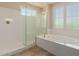 Bright bathroom features a glass enclosed shower and separate soaking tub with tile floors at 4724 S Anitole Way, Mesa, AZ 85212