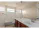Bathroom with dual sink vanity, large mirror, and shower-tub combination at 4724 S Anitole Way, Mesa, AZ 85212