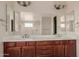 Bathroom with wood cabinets, double vanity, large mirror, and tile floors at 4724 S Anitole Way, Mesa, AZ 85212