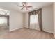 Carpeted bedroom includes ceiling fan and large window adorned with decorative valances at 4724 S Anitole Way, Mesa, AZ 85212
