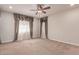 Spacious bedroom boasts two large windows with valances, ceiling fan and plush carpeting at 4724 S Anitole Way, Mesa, AZ 85212
