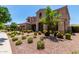 A well-manicured front yard with mature trees and desert landscaping enhances the curb appeal of this two-story home at 4724 S Anitole Way, Mesa, AZ 85212