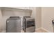 Modern laundry room with stainless steel washer and dryer appliances and storage shelves at 4724 S Anitole Way, Mesa, AZ 85212