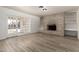 Spacious living room with light, wood-look floors, a brick fireplace, and glass doors to the backyard at 501 W Dublin St, Chandler, AZ 85225