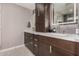Bathroom featuring double sinks, modern vanity, and decorative backsplash at 5314 N Las Casitas Pl, Phoenix, AZ 85016