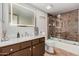 Bathroom featuring a white marble countertop, a brown vanity and a shower and tub combo at 5314 N Las Casitas Pl, Phoenix, AZ 85016