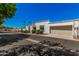 Attractive townhome featuring white stucco, a red tile awning, a garage, and lush landscaping at 5314 N Las Casitas Pl, Phoenix, AZ 85016