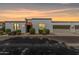 Charming townhome featuring white stucco, a red tile awning, a garage, and well-maintained landscaping at sunset at 5314 N Las Casitas Pl, Phoenix, AZ 85016