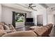Spacious living room featuring a comfortable sectional couch, ceiling fan, and a large window at 5314 N Las Casitas Pl, Phoenix, AZ 85016