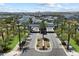 An aerial perspective shows a community entrance surrounded by palm trees, mountain views, and desert landscape at 5724 E Scarlet St, Mesa, AZ 85215