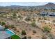 Expansive aerial view of a desert community featuring a backyard pool, mountain views, and desert landscaping at 5724 E Scarlet St, Mesa, AZ 85215