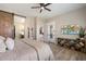 Spacious bedroom with barn door to bathroom, a ceiling fan, and a view of the kitchen and living area at 5724 E Scarlet St, Mesa, AZ 85215
