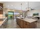 Bright, open kitchen with an island, pendant lighting, modern appliances, and sliding glass doors at 5724 E Scarlet St, Mesa, AZ 85215
