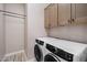 Convenient laundry room featuring an Electrolux washer and dryer, and overhead storage cabinets at 5724 E Scarlet St, Mesa, AZ 85215
