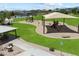 Aerial view of the community playground with picnic area and shade structure on green lawn at 5724 E Scarlet St, Mesa, AZ 85215