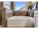 Luxurious soaking tub with stone tile surround and a view to the exterior of the home at 635 S Lanus Dr, Gilbert, AZ 85296