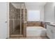 Spa-like bathroom features a glass enclosed shower and soaking tub with a window at 635 S Lanus Dr, Gilbert, AZ 85296