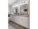Bathroom featuring double sink vanity with granite counters and decorative framed mirrors at 635 S Lanus Dr, Gilbert, AZ 85296