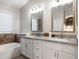 Bright bathroom features double sink vanity with granite counters and a soaking tub at 635 S Lanus Dr, Gilbert, AZ 85296