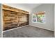 Comfortable bedroom featuring carpet, wood accent wall, and a bright window at 635 S Lanus Dr, Gilbert, AZ 85296