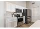 Modern kitchen appliances including stainless steel refrigerator, microwave, and oven with white cabinets at 635 S Lanus Dr, Gilbert, AZ 85296
