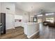 Bright, open-concept kitchen boasts white cabinets, quartz countertops, and stainless steel appliances overlooking the living area at 635 S Lanus Dr, Gilbert, AZ 85296