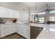 Beautiful kitchen featuring white cabinets, quartz countertops, stainless steel appliances, and an open layout to the living area at 635 S Lanus Dr, Gilbert, AZ 85296
