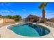 Backyard view of fenced in pool with palm tree, clear blue water, and patio area at 635 S Lanus Dr, Gilbert, AZ 85296