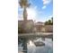 Poolside view of seating under an umbrella with palm trees at 635 S Lanus Dr, Gilbert, AZ 85296