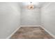 Empty living room featuring hardwood floors, white walls, and a modern light fixture at 7117 E Rancho Vista Dr # 3010, Scottsdale, AZ 85251