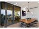 Modern dining room featuring a wood table, stylish chairs, and sliding glass doors to an outdoor seating area at 7180 E Kierland Blvd # 1116, Scottsdale, AZ 85254