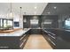 Sleek modern kitchen with white countertops, light wood floors, custom lighting, and gray cabinets at 7180 E Kierland Blvd # 1116, Scottsdale, AZ 85254