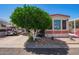 Cozy home featuring charming landscaping and a convenient golf cart parked in the driveway at 8700 E University Dr # 1205, Mesa, AZ 85207
