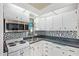 Charming kitchen with white cabinetry, stainless steel microwave, mosaic backsplash, and a double basin stainless steel sink at 8700 E University Dr # 1205, Mesa, AZ 85207
