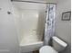 Bright bathroom featuring a tub shower with patterned curtains and a white toilet at 903 W Jacinto Cir, Mesa, AZ 85210
