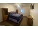 Bedroom featuring a large queen size bed with a floral comforter, ceiling fan and wood-look flooring at 903 W Jacinto Cir, Mesa, AZ 85210