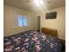 Cozy bedroom with wood flooring, window with blinds, a tv, and dresser at 903 W Jacinto Cir, Mesa, AZ 85210